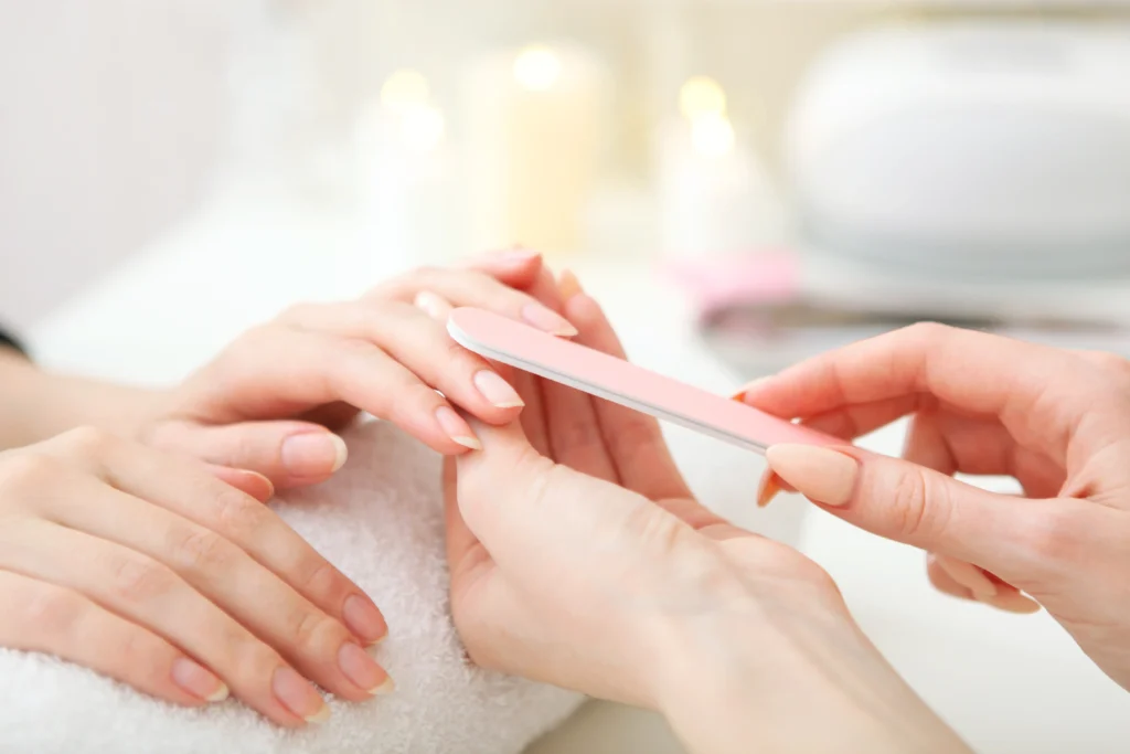 close up of manicure of medium length nails with a nail file
